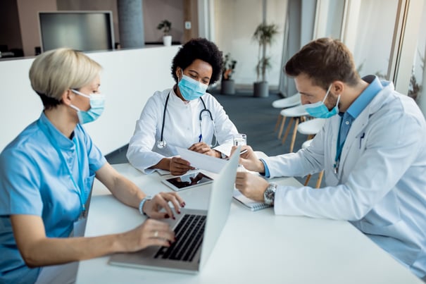 african-american-doctor-analyzing-medical-reports-with-her-colleagues-clinic