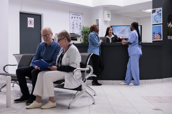 patient-nurse-sitting-reception-desk-talking-female-receptionist-about-disease-diagnosis-healthcare-support-diverse-people-working-health-center-registration-counter