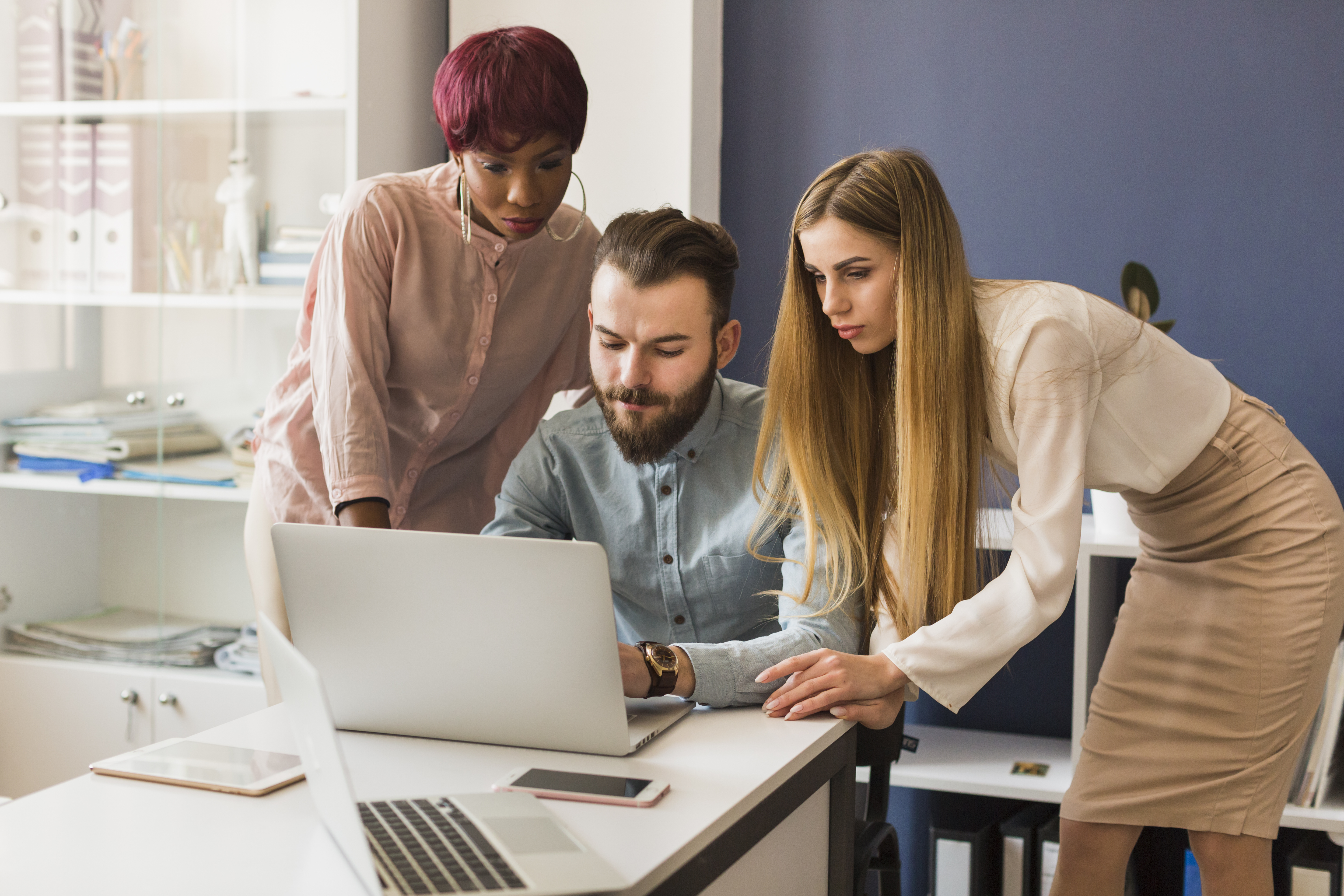 two-women-helping-man-with-project