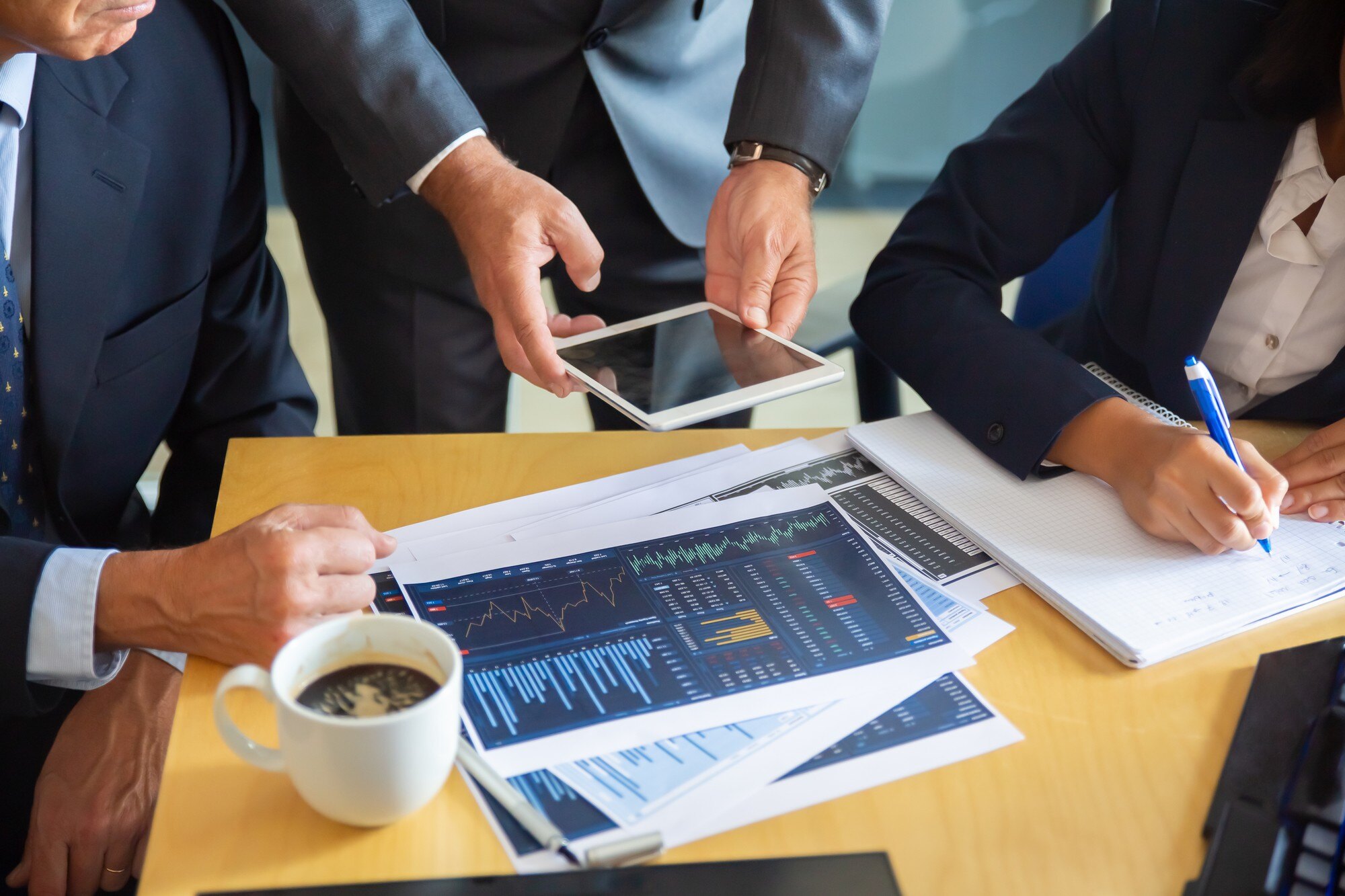 unrecognizable-business-partners-working-with-statistic-charts-businessman-holding-tablet-professional-content-businesswoman-making-notes-statistics-communication-partnership-concept